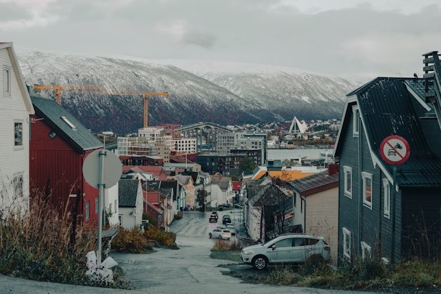Snow-covered Arctic landscape under the glowing Northern Lights in Tromsø